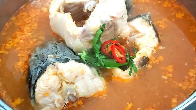 alt: Thưởng thức lẩu cá tầm Sapa cùng bún và rau sống